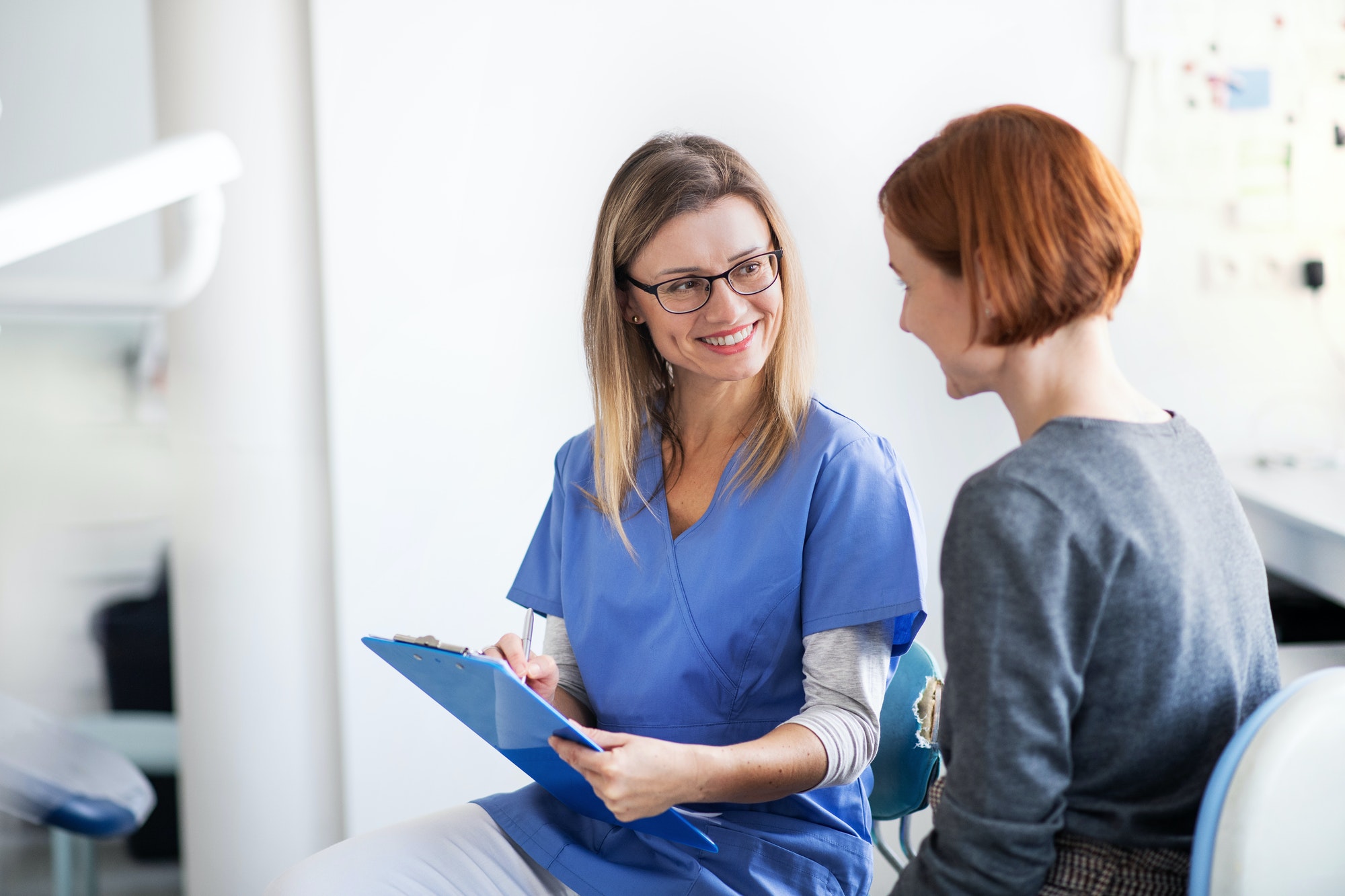 a woman has a dental check up in dentist surgery