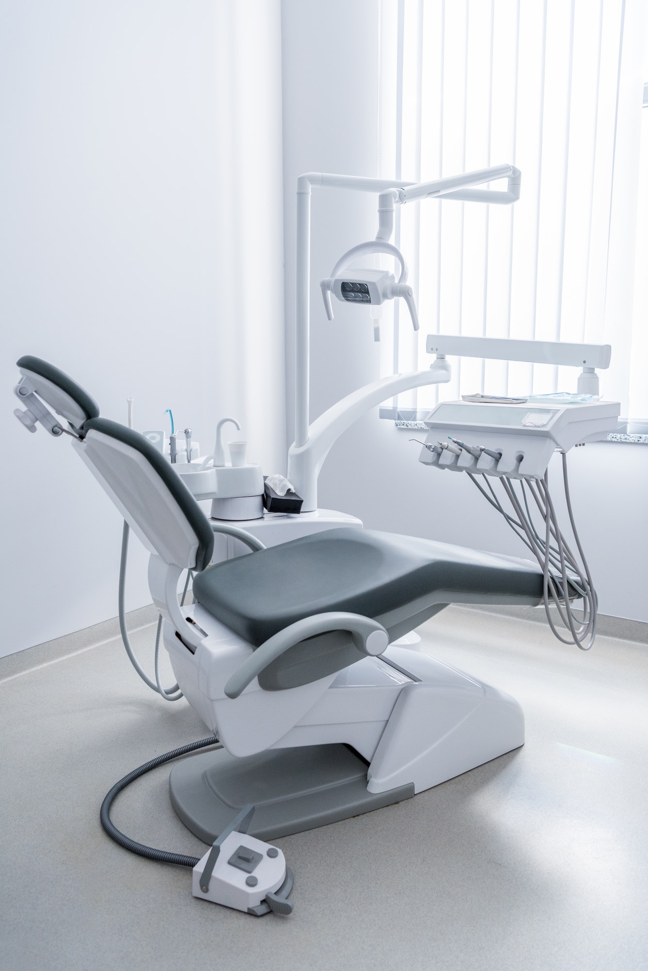 empty dentist office with chair and various dental equipment